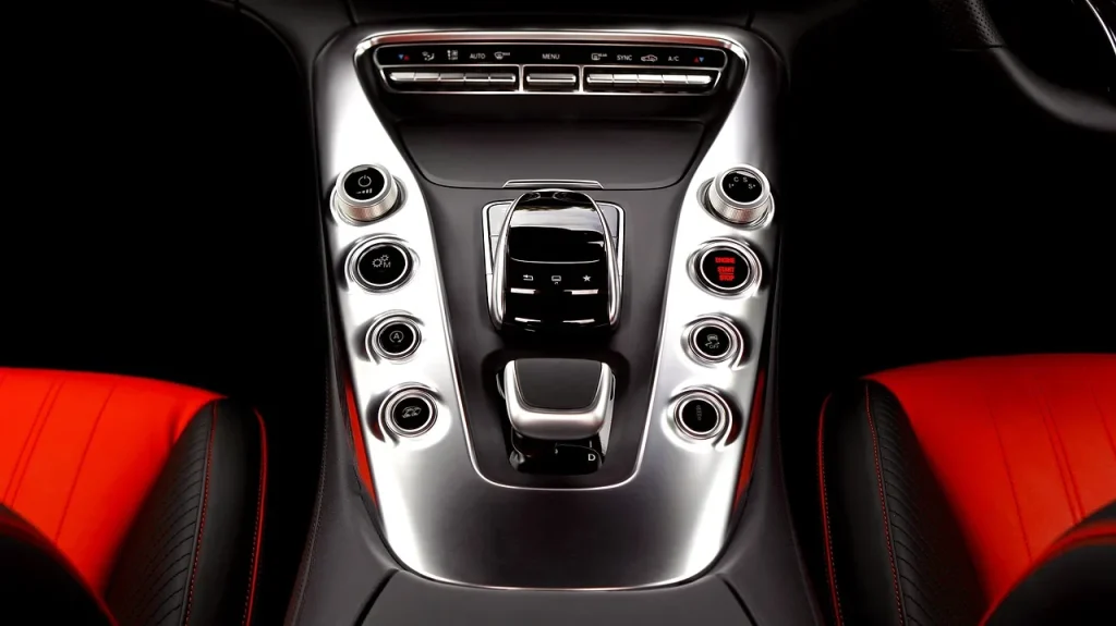 A person wipes car interior leather trim on a door panel with a microfiber cloth in natural light.