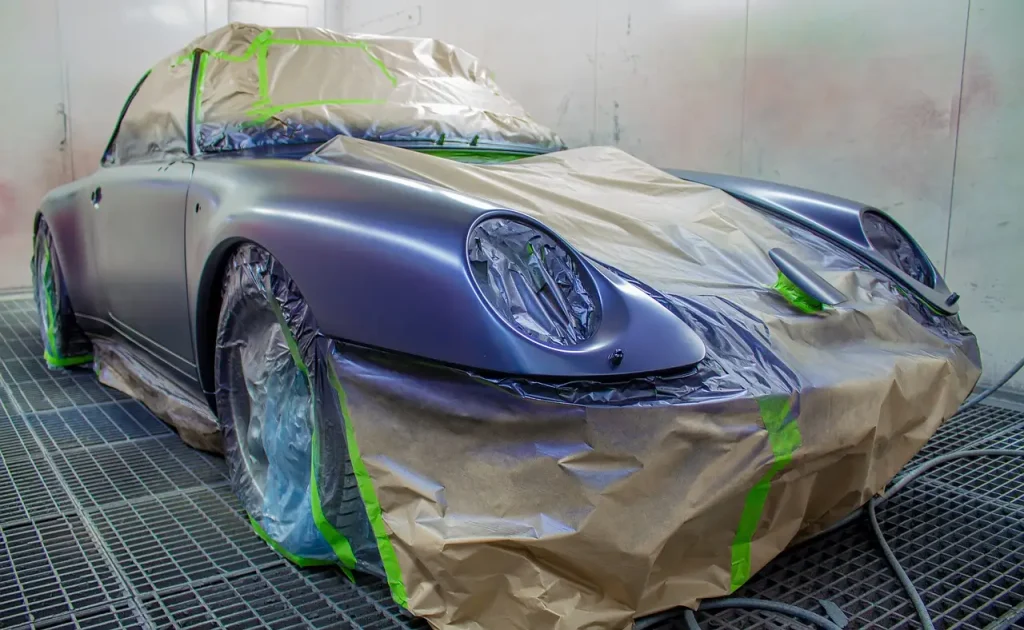 Car owner and detailer inspect clear-coat scratches on a silver sedan in daylight