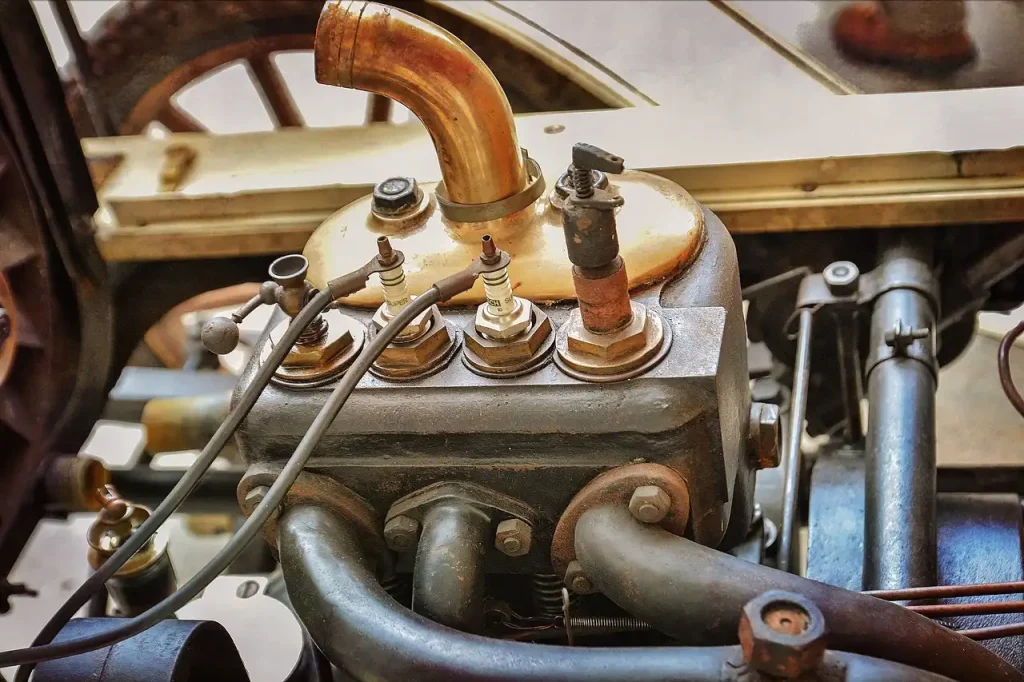 Mechanic and car owner inspecting spark plugs beside an open car hood before a road trip